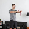Image of Theraband Non-Latex Resistance Exercise Tubing for Strength Training man using red tubing for chest exercise