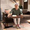 Image of Older woman using a couch tray table in her living room