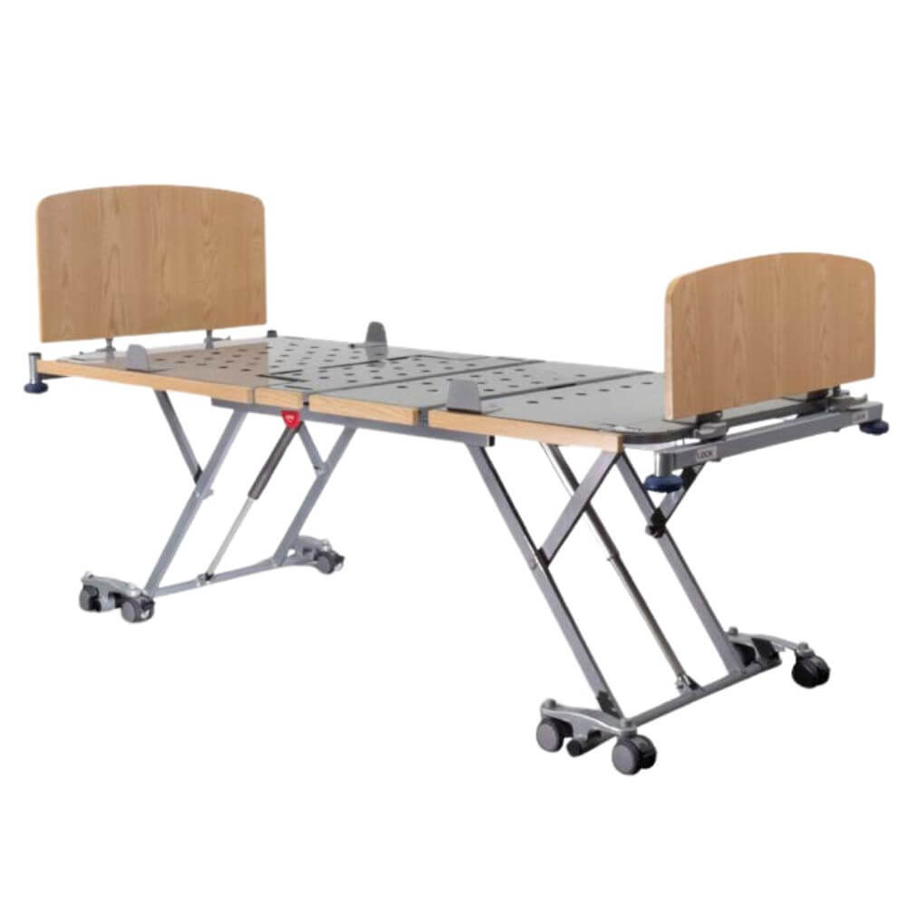 Electric Floorline Aged Care Bed with High Low Adjustment raised position showing scissor lift frame and wooden headboard