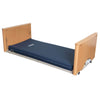 Image of Electric Floorline Care Bed with Low Height and Trendelenburg flat low floor position with wooden panels and blue mattress