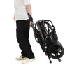 Image of FlyteMax Heavy Duty Carbon Fibre Electric Wheelchair folded for transport beside user
