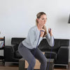 Image of Theraband Non-Latex Resistance Exercise Tubing for Strength Training woman performing squats with blue tubing