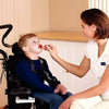 Image of Therapy Feeding Spoon for Lip Closure Training caregiver assisting child in wheelchair with feeding exercise