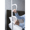 Image of Hands gripping both handles of the floor to ceiling pole beside the bed