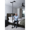 Image of Man sitting on the bed holding a black floor to ceiling grab bar