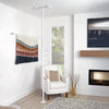 Image of White floor to ceiling security pole beside an armchair in the living room