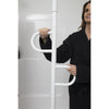 Image of Woman holding the double handles of a white floor to ceiling grab bar in the bathroom